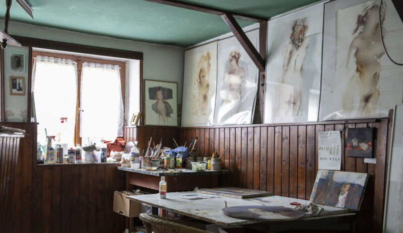 Künstleratelier mit Künstlerutensilien und Aktskizzen an der Wand